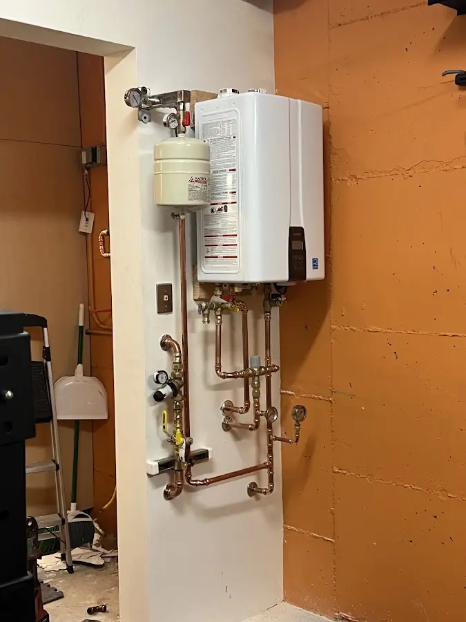 Plumbing technician inspecting water heater connections in Big Spring